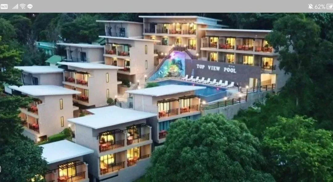 Aerial view of the resort and its pools at dusk with the island lights
